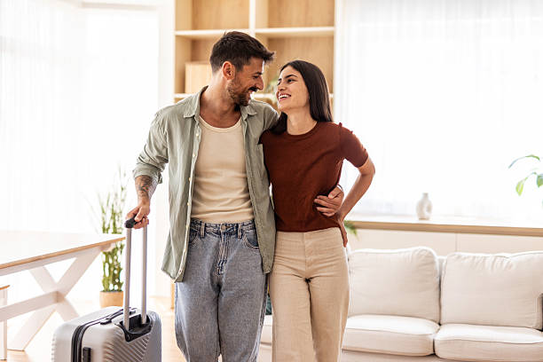 istock Happy couple leaving home for vacation with suitcase 2232419959