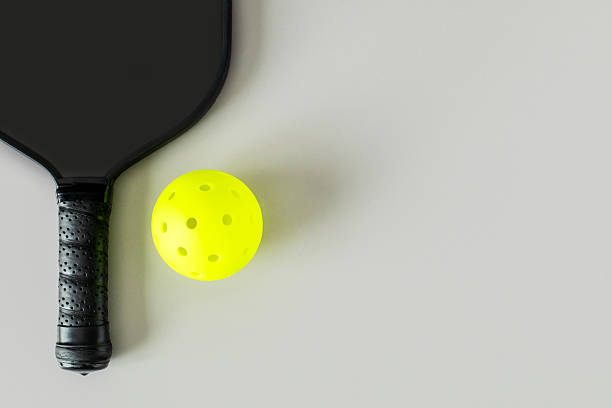 istock Pickleball Paddle and Yellow Ball on Minimalist Grey Background 2232421047