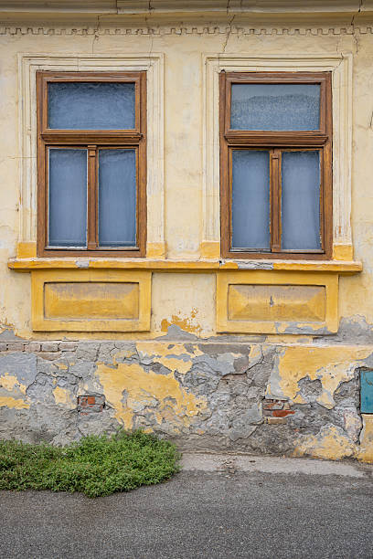 istock Wooden windows on an old yellow building. 2232421145