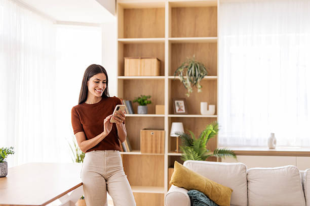 istock Young woman using smartphone at home: enjoying modern communication 2232422005