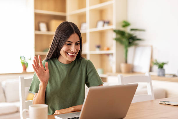istock Young woman waving hand while video conferencing at home 2232423016