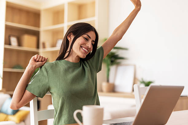 istock Young woman stretching at home office desk after work 2232423081