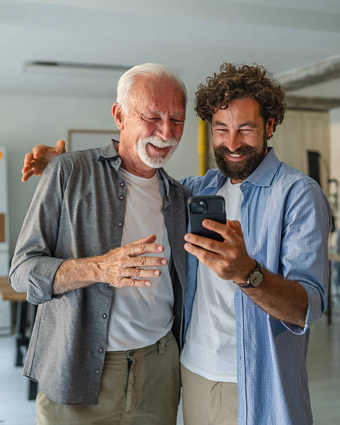 istock Adult son helping senior father using smart phone at home 2232424054