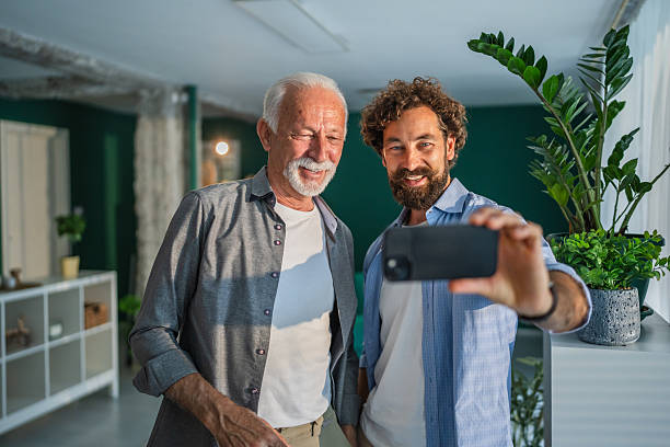 istock Father and son taking self portrait with smart phone at home 2232424712