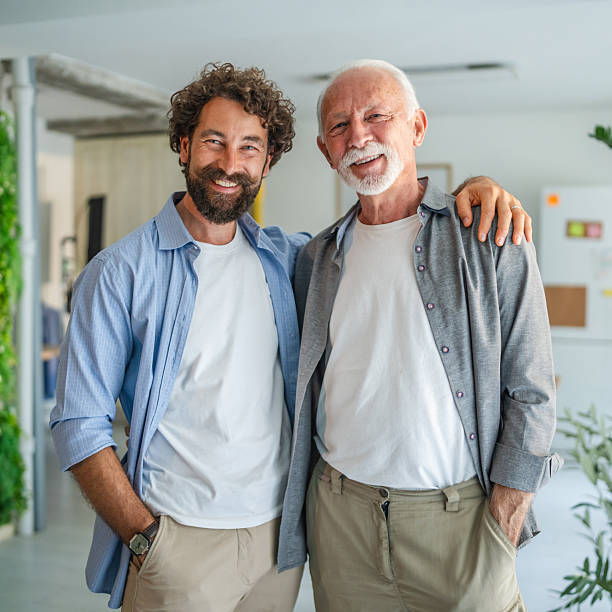 istock Father and son entrepreneurs smiling together in modern office 2232424714