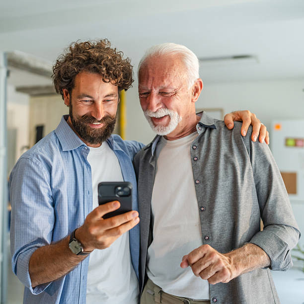 istock Adult son helping senior father using smart phone at home 2232424771