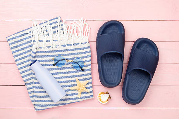 istock Beach towel with summer accessories on wooden background, top view 2232425936