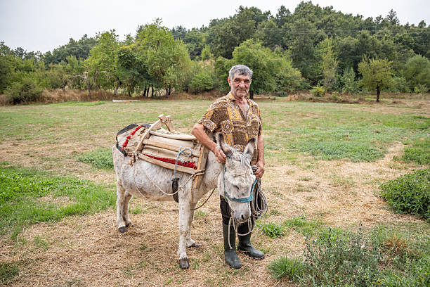 Kuratica, Ohrid, North Macedonia. September 6, 2024. A man with his donkey in rural North Macedonia.