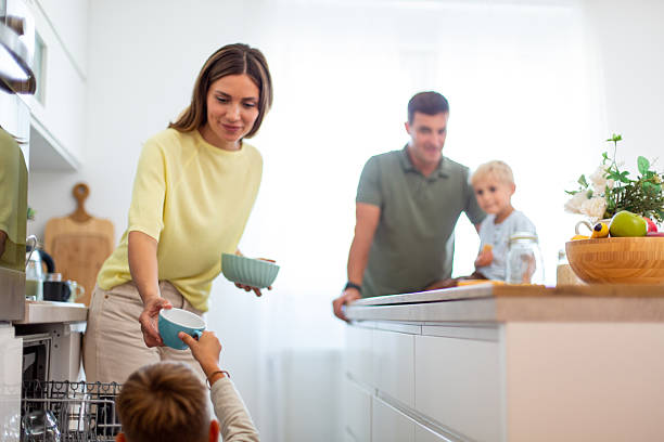 istock Family unloading dishwasher together in modern kitchen 2232429124