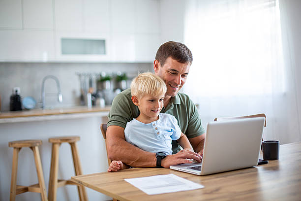 istock Father and son using laptop together at home 2232429959