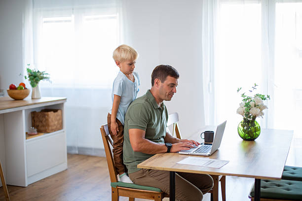 istock Father working from home while playful son is climbing on his back 2232430017