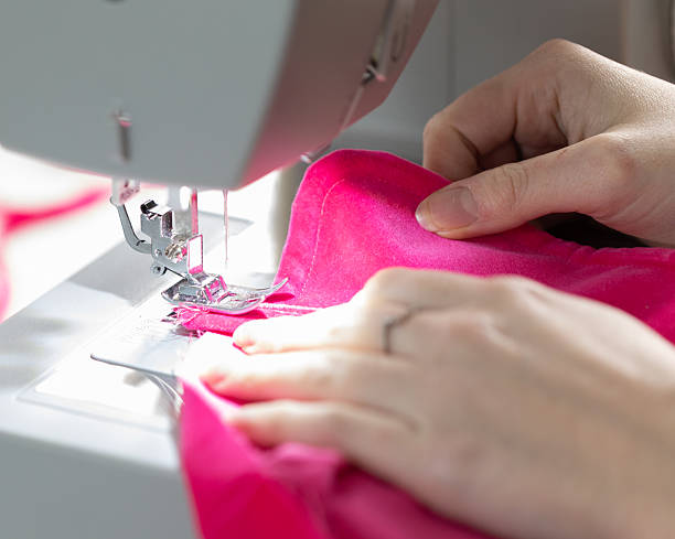istock Sewing Bright Pink Fabric with a Sewing Machine 2232431716