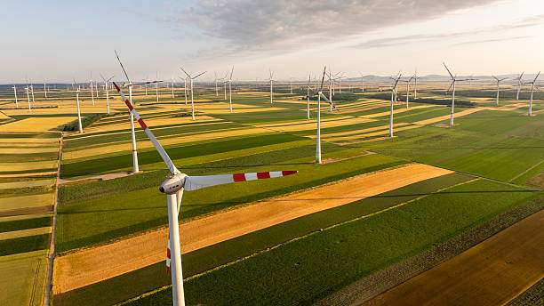 istock Expansive Wind Turbines Over Vibrant Patchwork Agricultural Fields at Sunset 2232434659