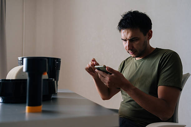 istock Technician carefully reading instructions on smartphone while cleaning filter of modern air humidifier, ensuring proper maintenance and optimal performance. 2232434822