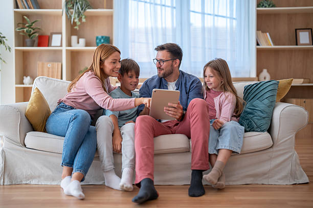 istock Family enjoying time together on the sofa browsing a tablet 2232434919