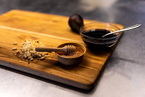 istock Rustic Kitchen Ingredients with Honey, Pine Nuts, and Balsamic Vinegar on Wooden Board 2232437979