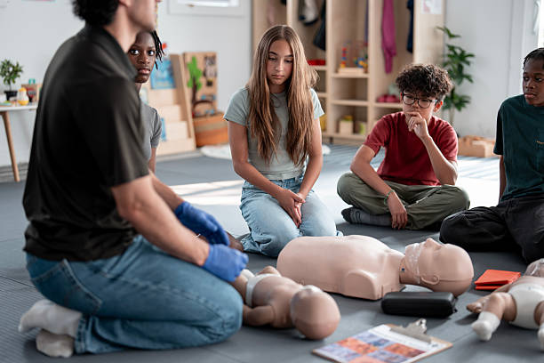 istock Youth Participating in Hands-On CPR Training with Instructor and Dummy 2232441912