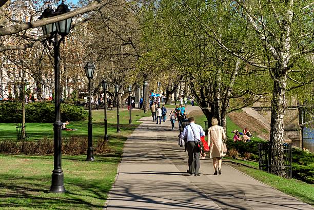 Moscow, Russia - 25, August, 2024.\nParks and green areas for recreation and entertainment in the capital.\nPeople walking along the evening alley along Chistye Prudy.