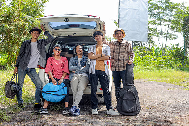 istock Friends Sitting on Car Trunk During Road Trip 2232442998