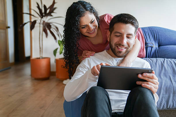 istock Happy couple at home watching a video on a digital tablet 2232443098