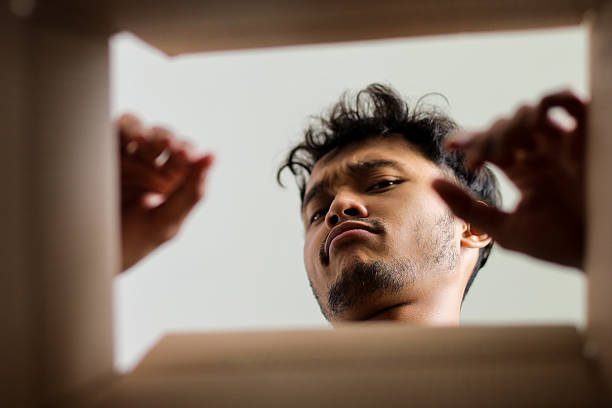 istock Curious Male Peering Down Into Package Seen From An Intriguing Inside Perspective 2232443548
