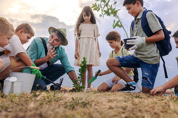 istock children learning about enviroment by planting a tree together with the teacher 2232453263