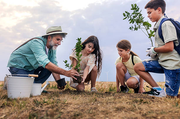 istock children learning about enviroment by planting a tree together with the teacher 2232453264