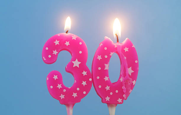 istock Burning pink birthday cake candles on blue background. Number 30. 2232458103