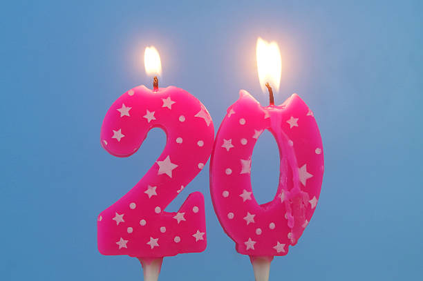 istock Burning pink birthday cake candles on blue background. Number 20. 2232458104