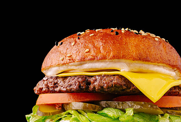 istock Gourmet beef burger with fresh toppings on a black background 2232459681