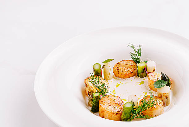 istock Seared scallops served on a delicate puree with fresh herbs and vegetables 2232459950