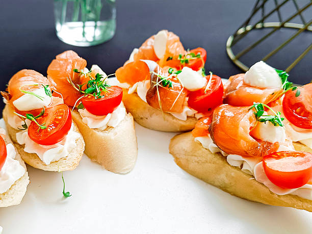 Beautifully served sandwiches with red fish and vegetables. Close-up.