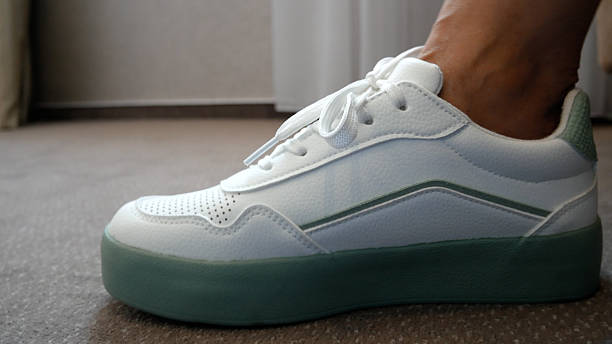 istock Women's hands tie shoelaces in sneakers. 2232461568