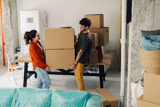 istock Young couple carrying boxes into new apartment 2232462161