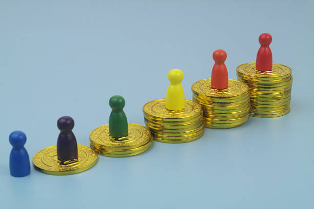 istock People figures on different stacks of gold money. 2232462673