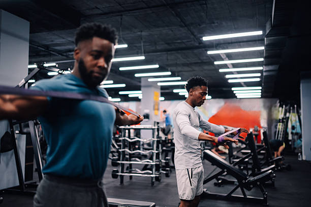 istock Two young men training with resistance bands in the gym 2232464363