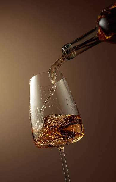 istock Pouring white wine from a bottle into a glass. 2232464387