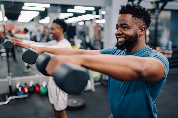 istock Two young men lifting weights in the gym 2232464412