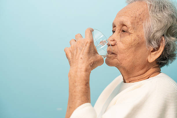 istock An elderly Asian woman drinks clean water from a glass. 2232464553