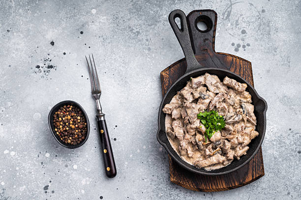 istock Creamy beef stroganoff with fresh greenery, savory mushroom sauce and caramelized onions in a skillet. grey background. top view 2232465044