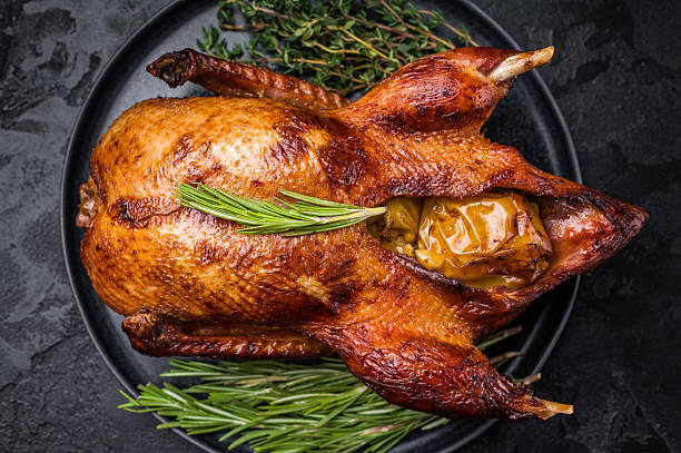istock Grilled duck with apples on plate with herbs. black background. top view 2232468717
