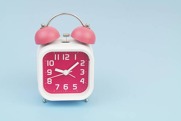 istock Red and white alarm clock on blue background. 2232469220