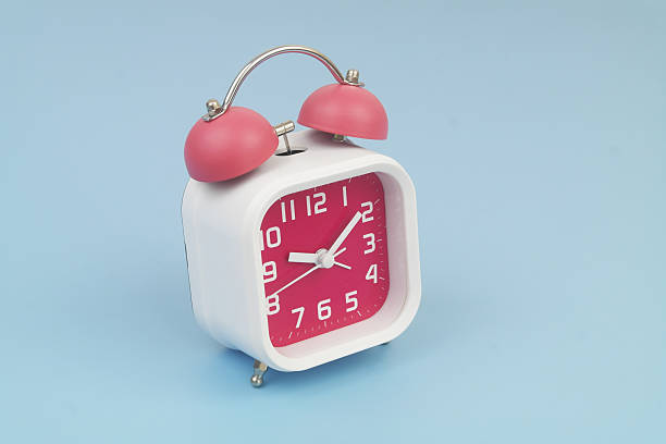 istock Red and white alarm clock on blue background. 2232469222