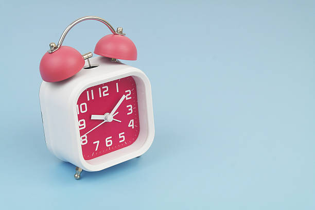 istock Red and white alarm clock on blue background. 2232469223