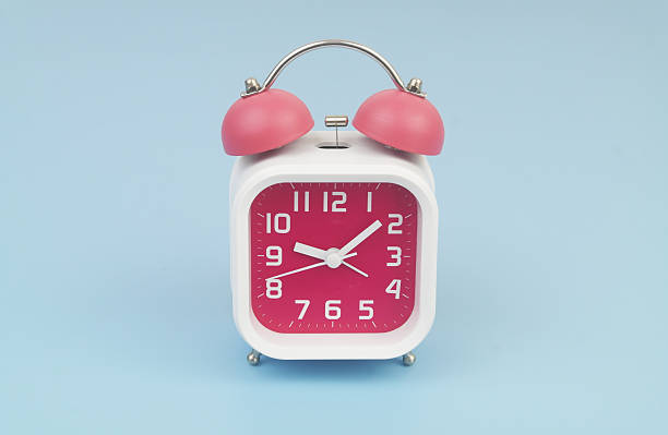 istock Red and white alarm clock on blue background. 2232469230