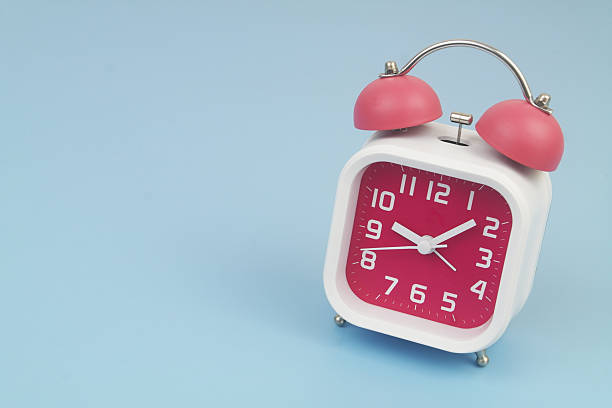 istock Red and white alarm clock on blue background. 2232469231