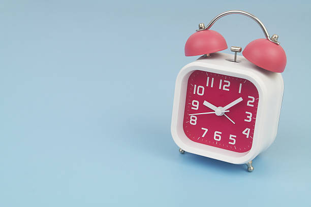 istock Red and white alarm clock on blue background. 2232469237