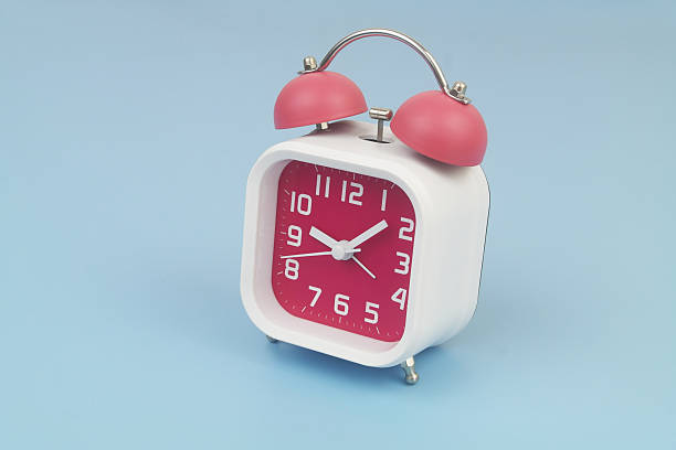 istock Red and white alarm clock on blue background. 2232469238
