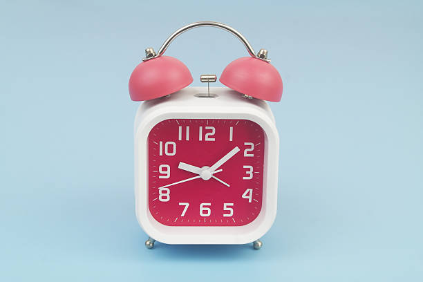 istock Red and white alarm clock on blue background. 2232469240