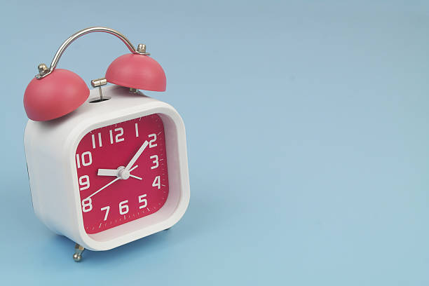 istock Red and white alarm clock on blue background. 2232469242